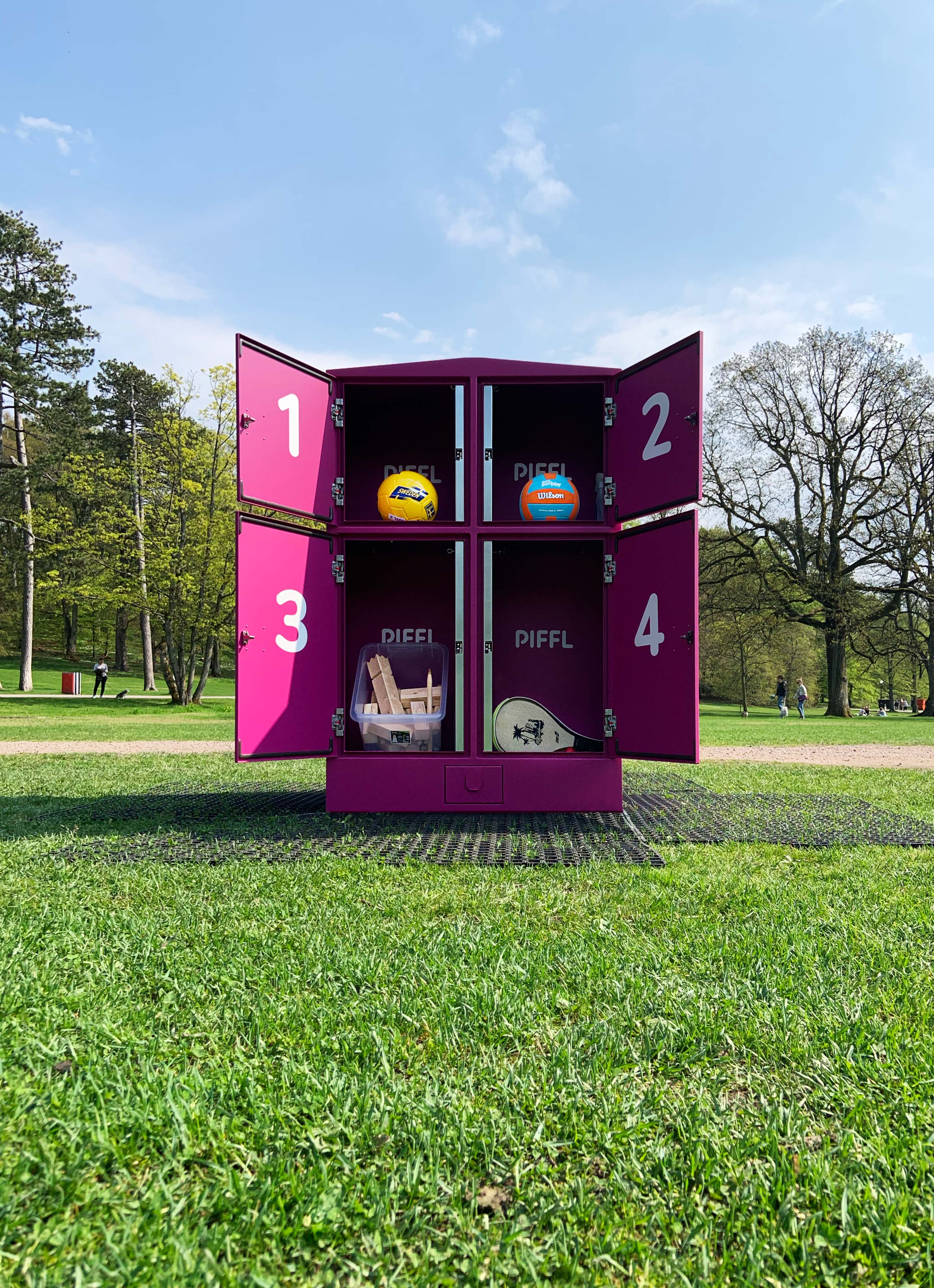 En kille spelar basket på en upplyst basketplan sent på kvällen